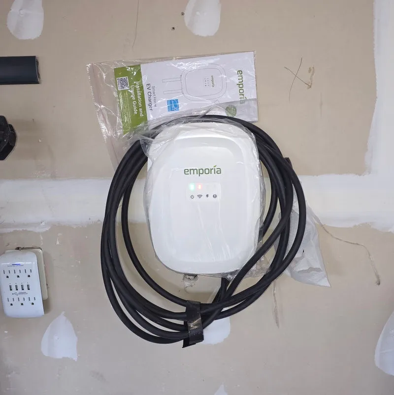 Level 2 EV charger installed beside a residential garage parking space